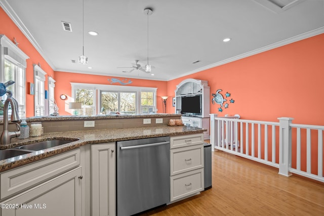 kitchen with a sink, visible vents, stainless steel dishwasher, light wood finished floors, and crown molding