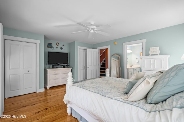 bedroom featuring ceiling fan, ensuite bathroom, light wood-style flooring, and multiple closets