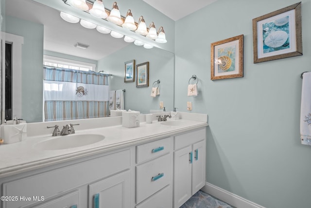 bathroom featuring visible vents, a sink, baseboards, and double vanity