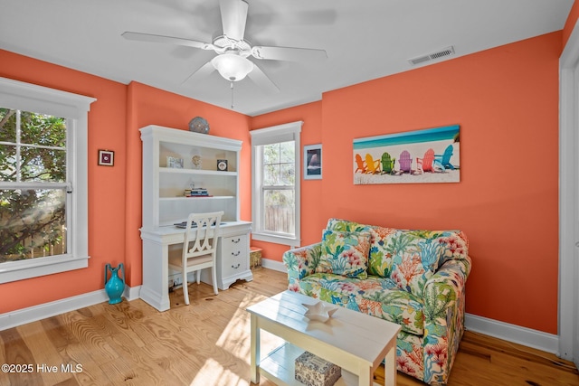 interior space featuring ceiling fan, wood finished floors, visible vents, and baseboards