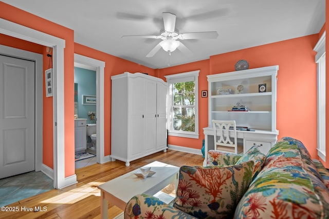 living area with ceiling fan, light wood-style flooring, and baseboards