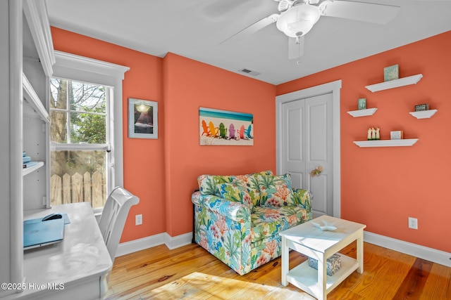 interior space with visible vents, ceiling fan, baseboards, and wood finished floors