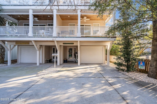 view of front facade featuring a garage, concrete driveway, a balcony, and a ceiling fan