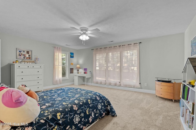 bedroom with a ceiling fan, light carpet, a textured ceiling, and baseboards