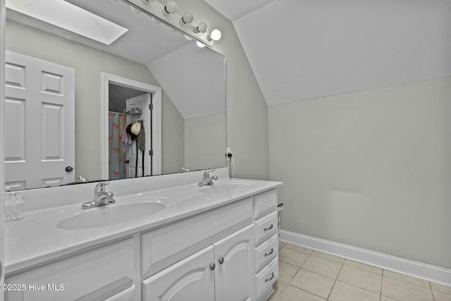 bathroom featuring double vanity, tile patterned flooring, a sink, and baseboards