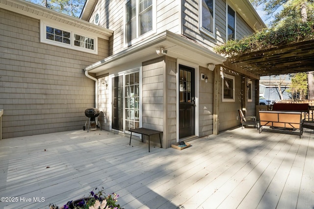 wooden terrace with area for grilling, a jacuzzi, and a pergola