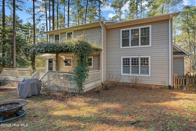 back of house with a deck and an outdoor fire pit