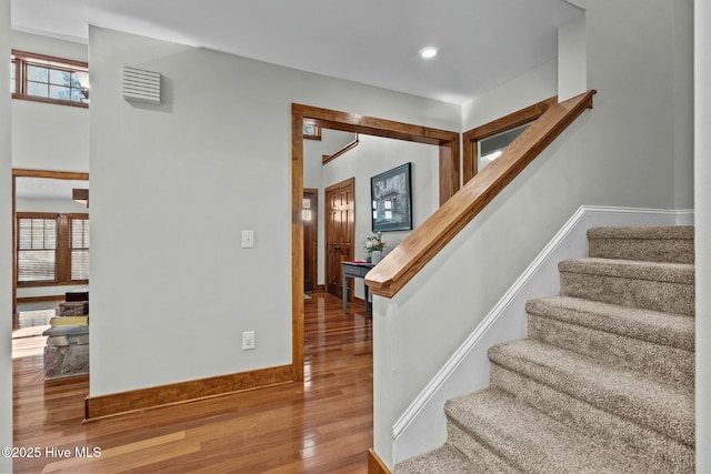 stairway with visible vents, baseboards, wood finished floors, and recessed lighting