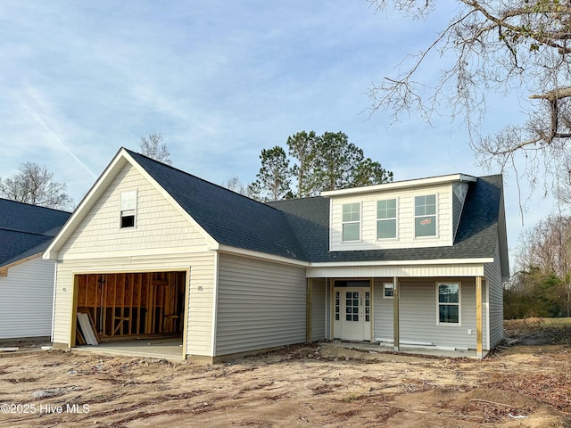 view of front of property featuring an attached garage and a shingled roof