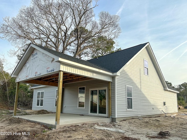 rear view of property with a patio area and a shingled roof