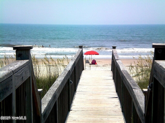 surrounding community with a water view and a view of the beach