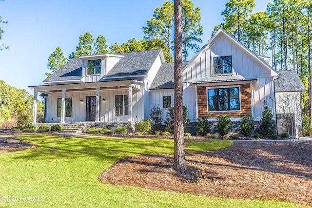 modern inspired farmhouse featuring roof with shingles, a porch, board and batten siding, and a front yard