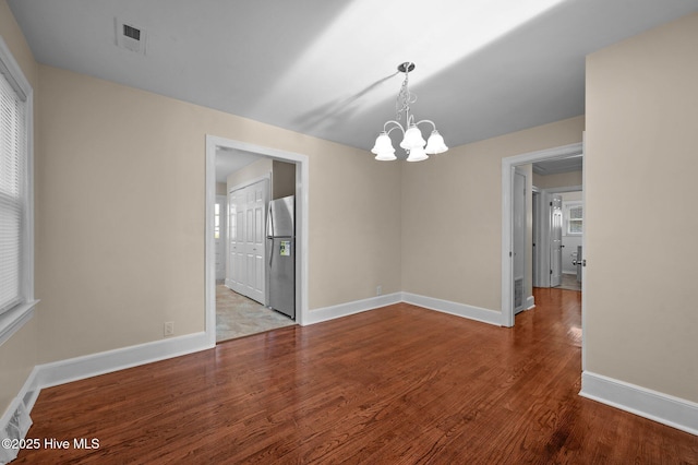 unfurnished dining area featuring light hardwood / wood-style floors and an inviting chandelier