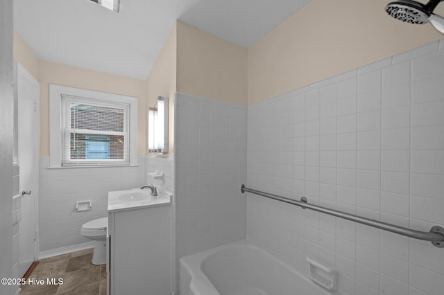 bathroom featuring toilet, tile patterned flooring, tile walls, and vanity