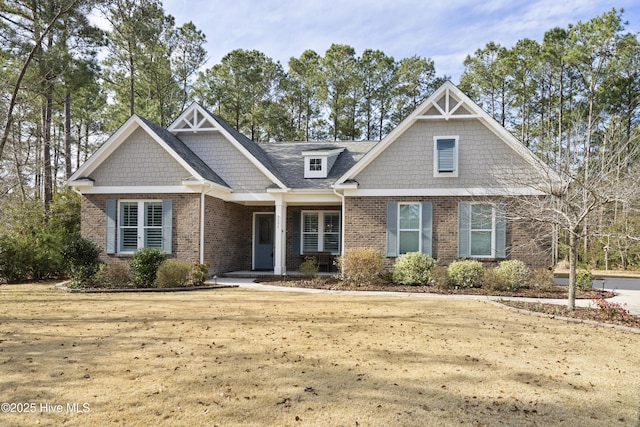 craftsman inspired home featuring a front yard and brick siding