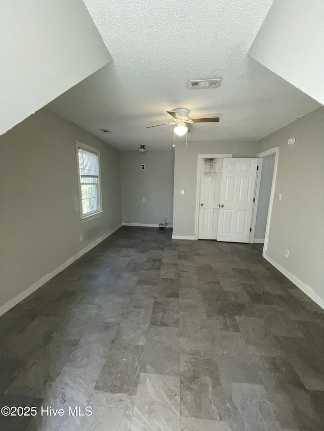 unfurnished living room with a textured ceiling and ceiling fan