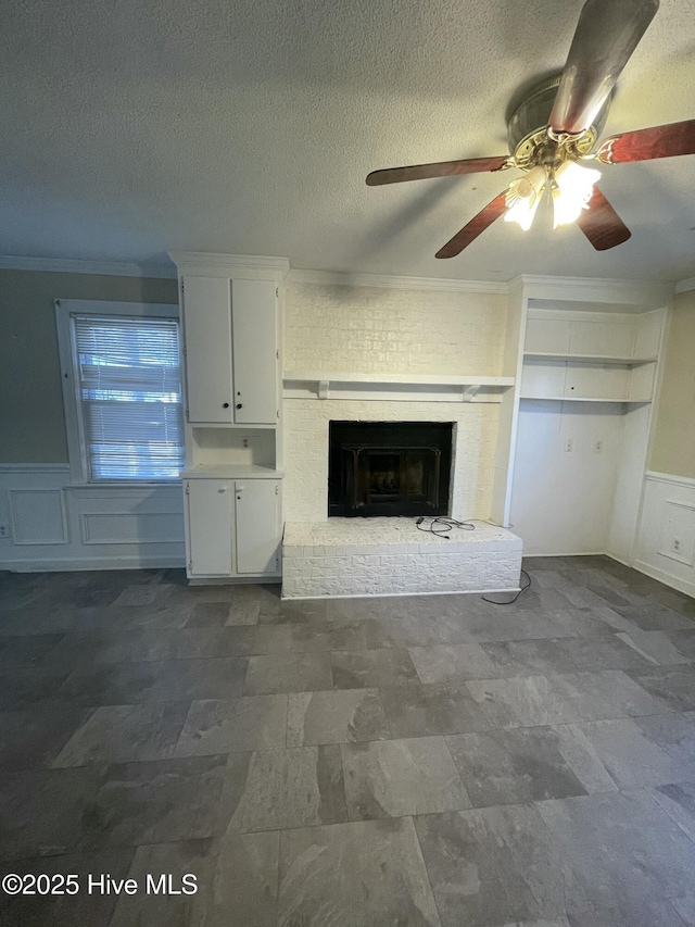 unfurnished living room with a brick fireplace, crown molding, and a textured ceiling