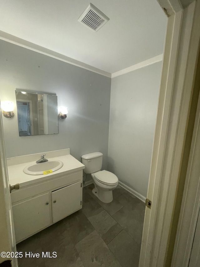 bathroom with crown molding, vanity, and toilet