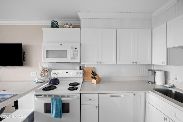 kitchen with white appliances, white cabinets, and a sink