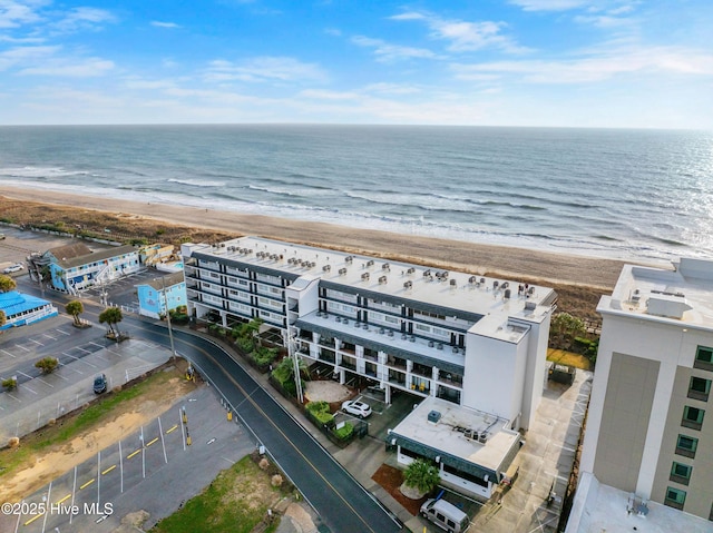 birds eye view of property with a water view and a beach view