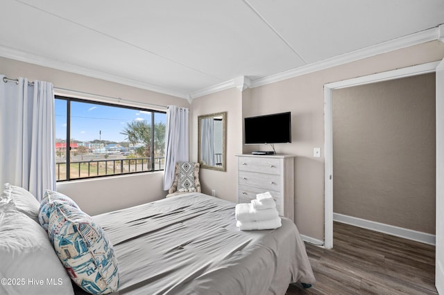 bedroom featuring dark wood finished floors, crown molding, and baseboards