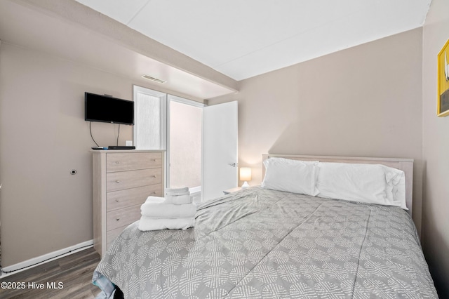 bedroom featuring baseboards and wood finished floors