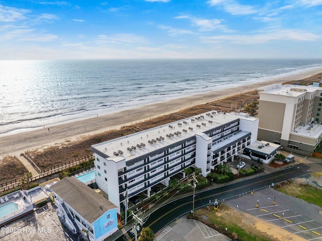 bird's eye view featuring a water view and a beach view