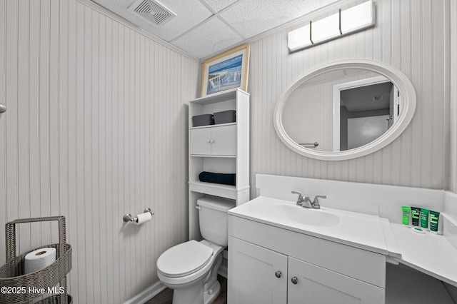 bathroom with toilet, visible vents, a drop ceiling, and vanity