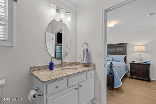 2011 Fisher St, Morehead City, NC 28557 - ensuite bathroom with vanity, ornamental molding, and wood finished floors