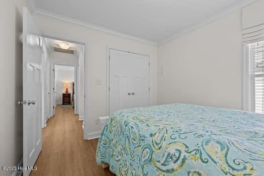 2011 Fisher St, Morehead City, NC 28557 - bedroom featuring ornamental molding, wood finished floors, and attic access