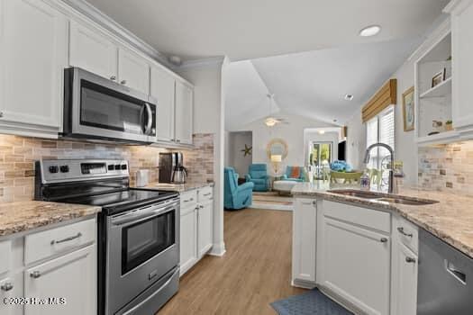 2011 Fisher St, Morehead City, NC 28557 - kitchen with stainless steel appliances, white cabinets, decorative backsplash, open floor plan, and light stone countertops