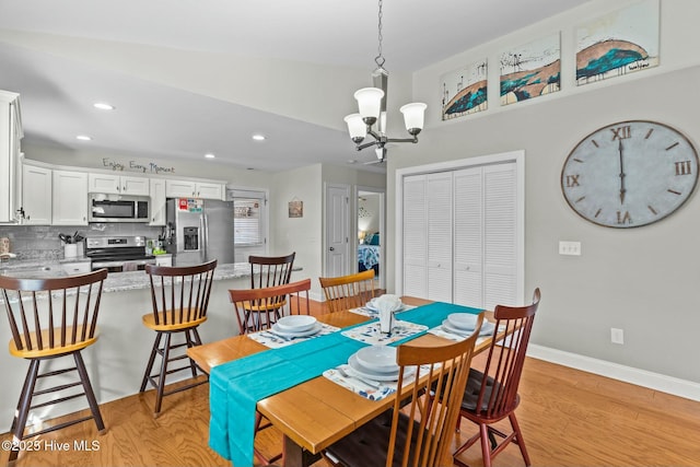 dining room with a chandelier, recessed lighting, light wood-type flooring, and baseboards