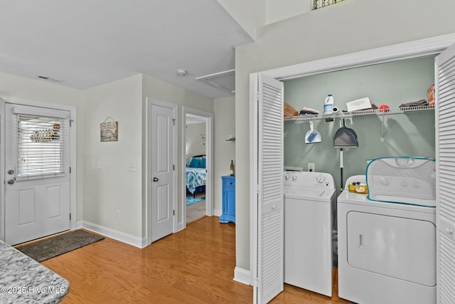 washroom with laundry area, visible vents, light wood finished floors, and separate washer and dryer