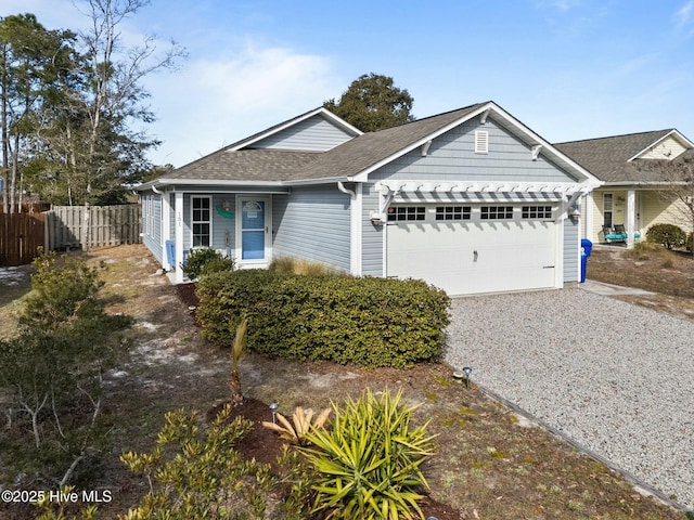 single story home with an attached garage, driveway, fence, and roof with shingles