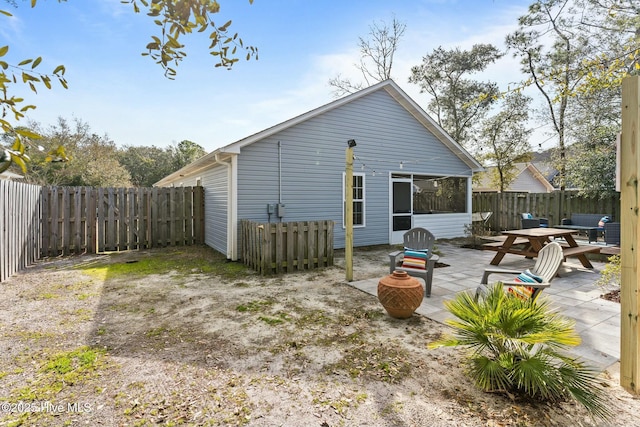 rear view of property featuring a sunroom, a fenced backyard, and a patio