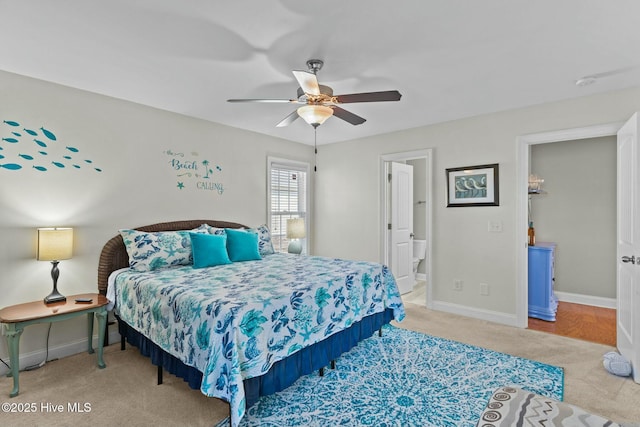 carpeted bedroom featuring connected bathroom, baseboards, and a ceiling fan