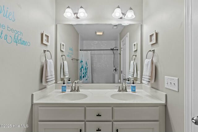 full bathroom featuring double vanity, a shower with curtain, and a sink