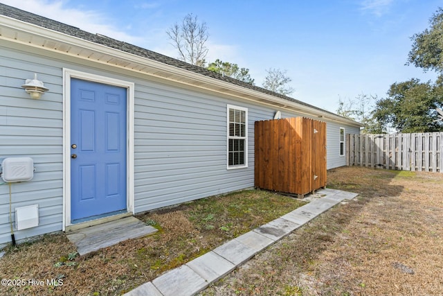 entrance to property featuring a yard and fence