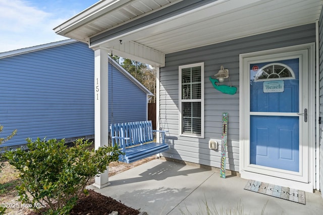 view of exterior entry with a porch