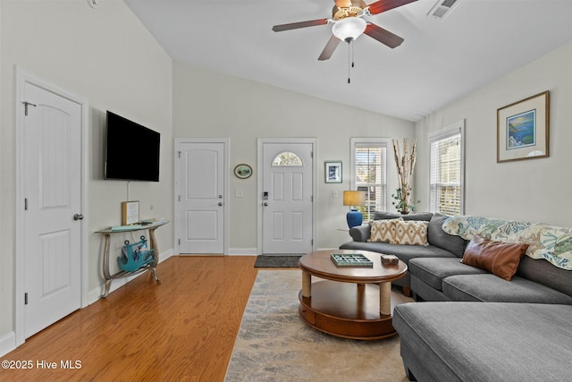 living area with lofted ceiling, ceiling fan, light wood-style flooring, visible vents, and baseboards