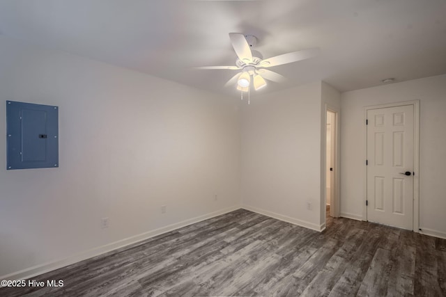 empty room featuring ceiling fan, electric panel, baseboards, and dark wood-style flooring