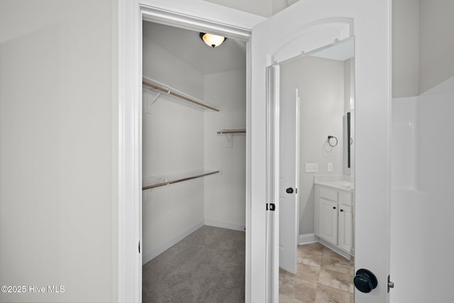 spacious closet featuring light colored carpet