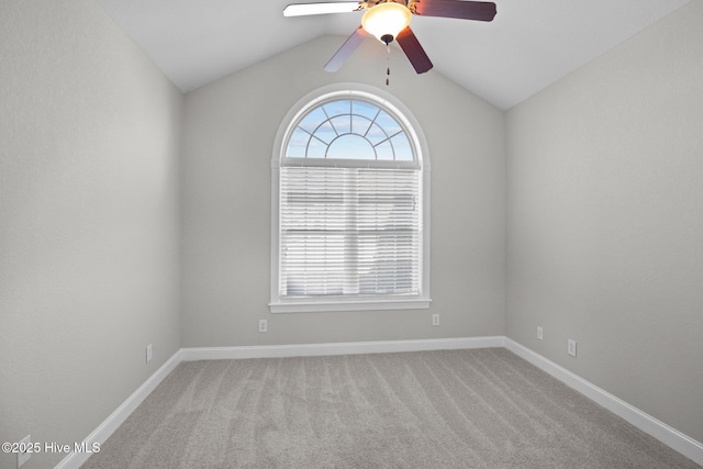 carpeted spare room with ceiling fan and vaulted ceiling