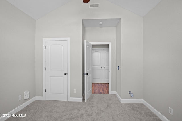 unfurnished bedroom with light carpet and vaulted ceiling