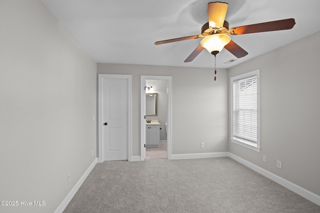 unfurnished bedroom with ceiling fan, light carpet, and ensuite bathroom