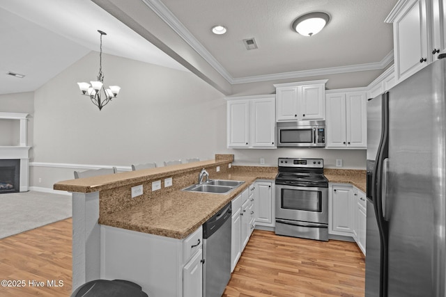 kitchen with sink, white cabinetry, stainless steel appliances, and kitchen peninsula