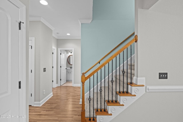 staircase featuring hardwood / wood-style flooring and crown molding