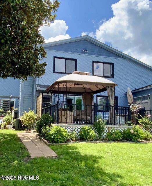 rear view of house featuring a lawn and a gazebo