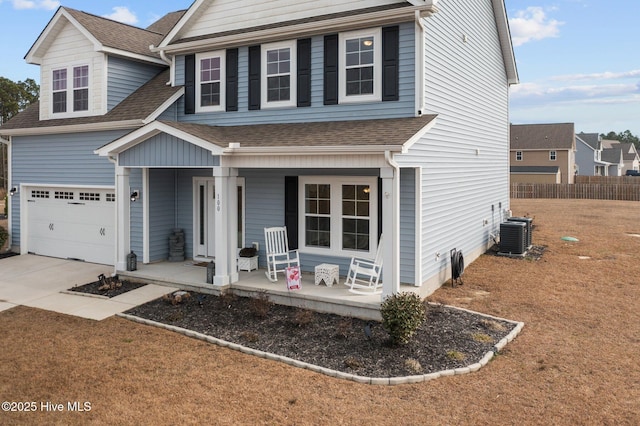 traditional home featuring a porch, a shingled roof, concrete driveway, central AC, and a garage