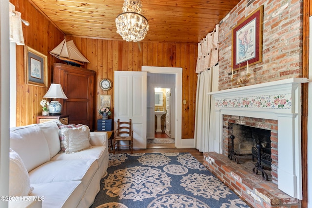 121 Dolphin Ln, Sneads Ferry, NC 28460 - living room featuring wooden ceiling, a chandelier, wooden walls, a brick fireplace, and wood finished floors